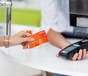 Persona realizando un pago con tarjetas de crédito en un datáfono.