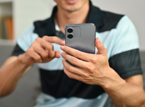 mano usando teléfono para consultar saldo en banca digital con iconos de transacción verificada al banco.
