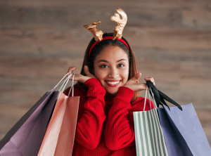 Mujer feliz con bolsas de regalo disfrutando las compras de regalos para Navidad Tarjeta Cencosud